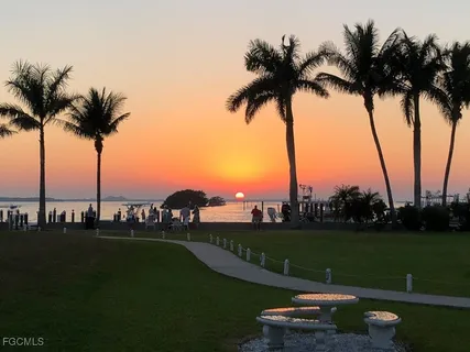 a view of lake with a table and palm trees