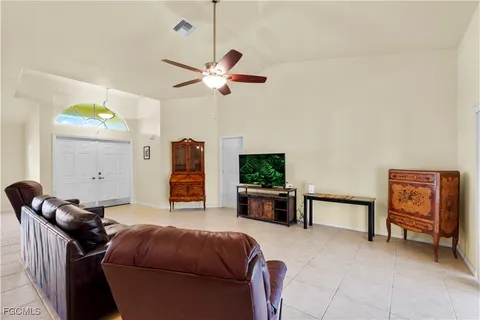 a living room with furniture a ceiling fan and a rug