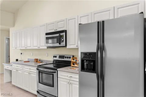 a kitchen with stainless steel appliances white cabinets and a refrigerator