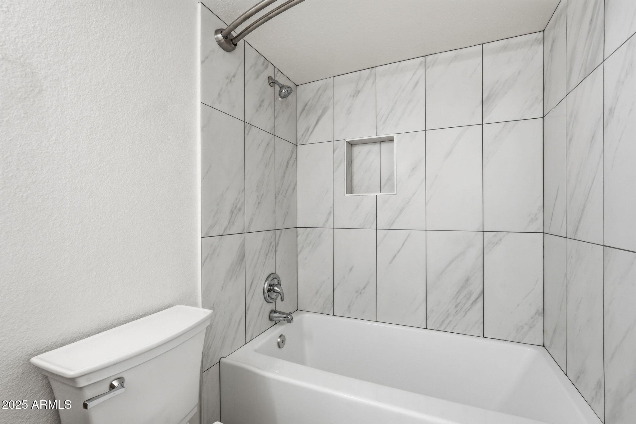 4201 East Camelback Road, Unit 74 Phoenix, AZ 85018 - Photo 17 of 20 a bathroom with a bathtub and toilet