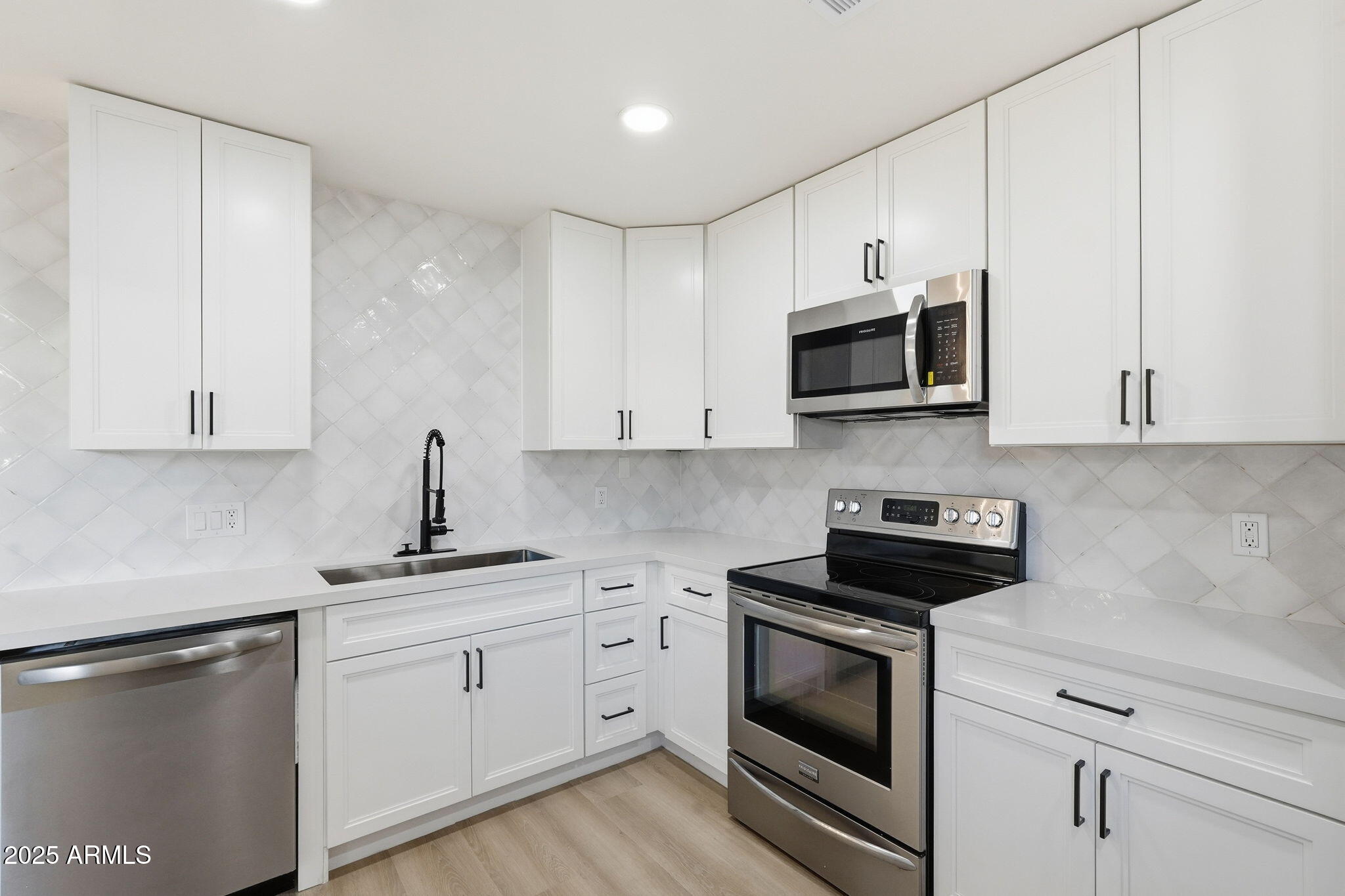 4201 East Camelback Road, Unit 74 Phoenix, AZ 85018 - Photo 2 of 20 a kitchen with white cabinets and stainless steel appliances