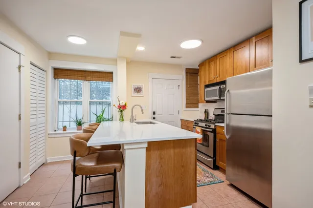 a kitchen with stainless steel appliances granite countertop a refrigerator and a table