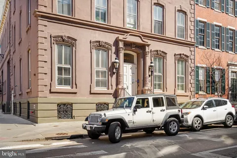 a white building that has a lots of cars parked in front of it