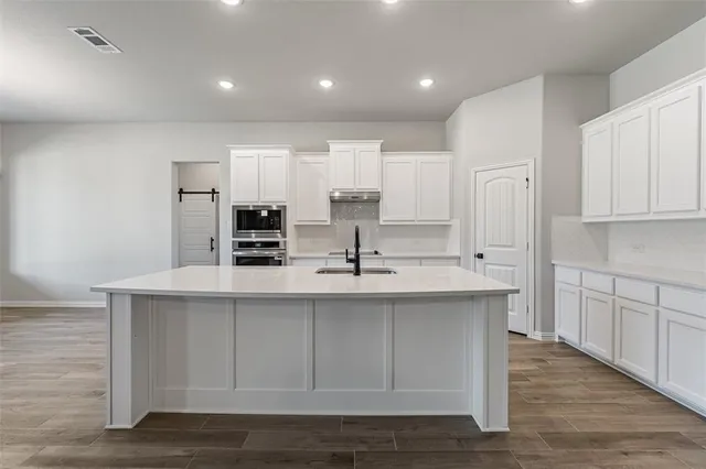 a kitchen with kitchen island sink stove and refrigerator