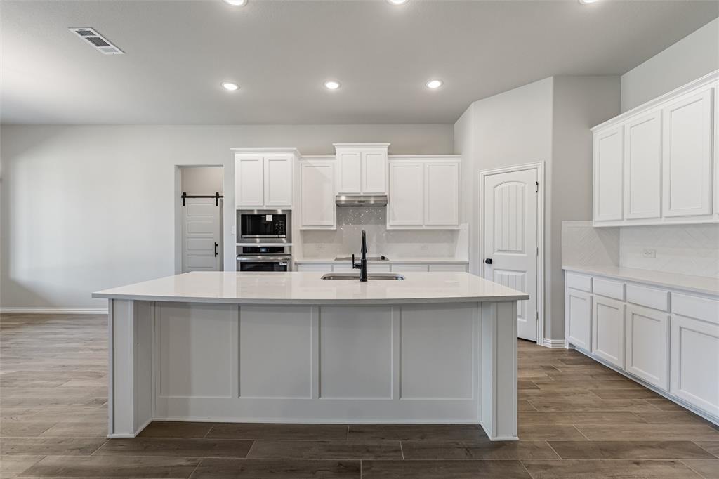 140 Oak Grv Way Springtown, TX 76082 - Photo 11 of 40 a kitchen with kitchen island sink stove and refrigerator