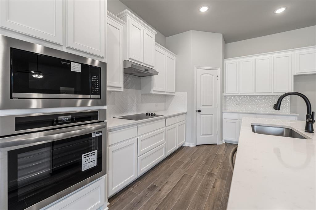 140 Oak Grv Way Springtown, TX 76082 - Photo 13 of 40 a kitchen with stainless steel appliances a stove microwave and sink