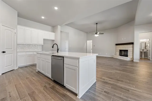 a kitchen with kitchen island a sink dishwasher a stove and a refrigerator with wooden floor