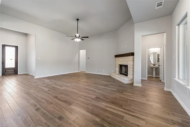 a view of empty room with wooden floor and fireplace
