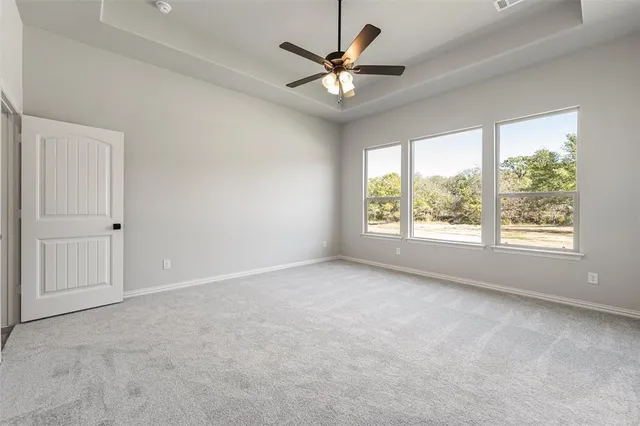 an empty room with windows and ceiling fan