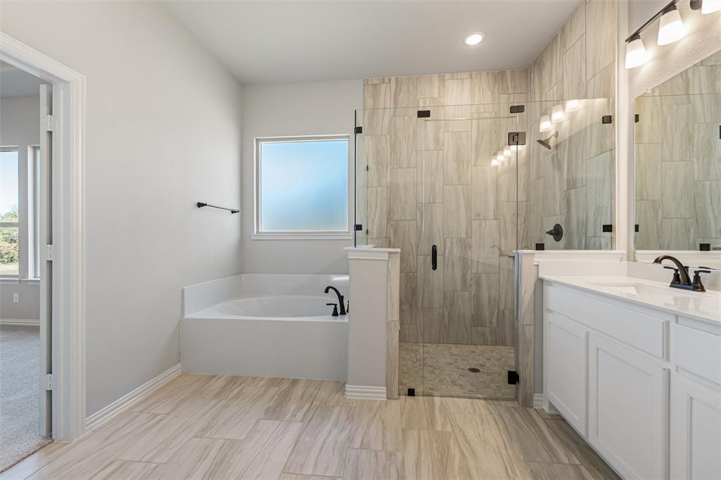 140 Oak Grv Way Springtown, TX 76082 - Photo 32 of 40 a bathroom with a bathtub a sink and a shower