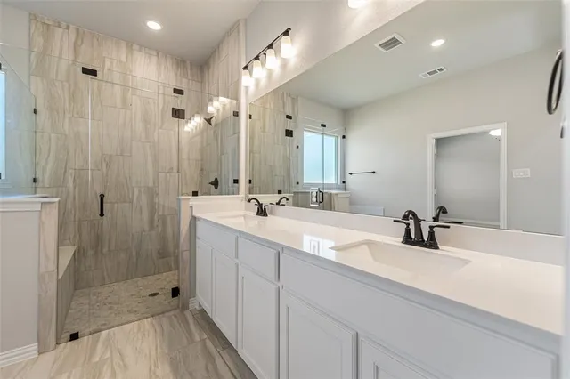 a bathroom with sink shower and mirror