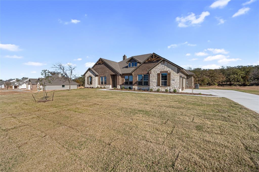 140 Oak Grv Way Springtown, TX 76082 - Photo 5 of 40 a front view of a house with a yard