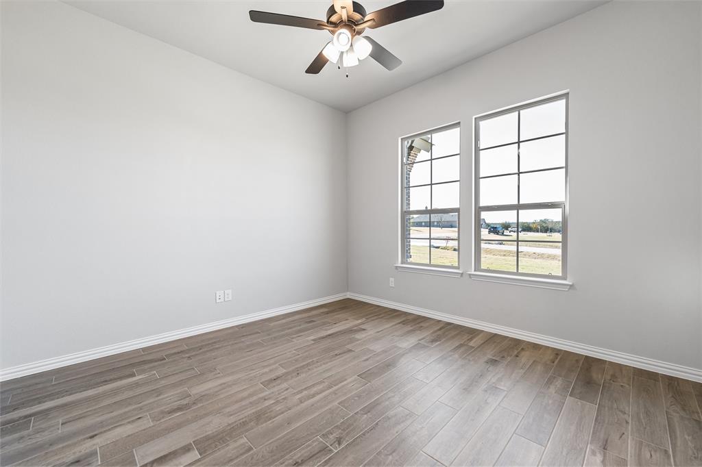 140 Oak Grv Way Springtown, TX 76082 - Photo 10 of 40 an empty room with wooden floor chandelier fan and windows