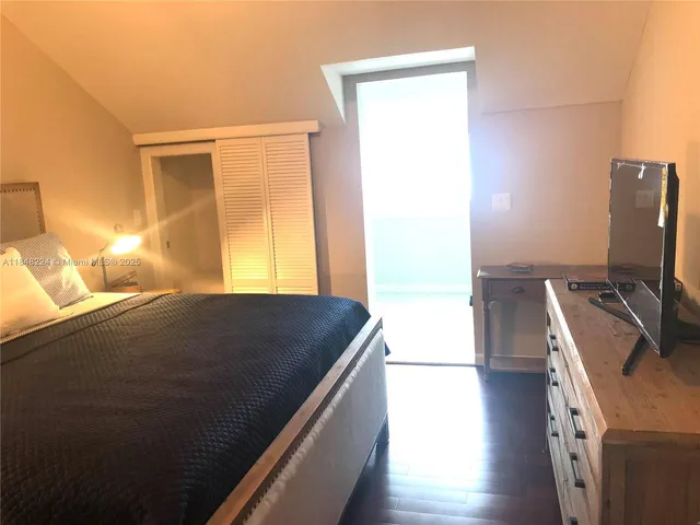 a room with a bed and a computer on the table