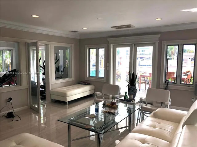 a living room with furniture and floor to ceiling windows