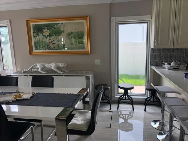 a view of a dining room with furniture a rug and wooden floor