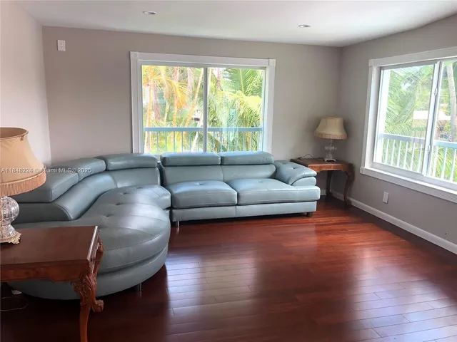 a bed sitting in a bedroom next to a window and a wooden floor