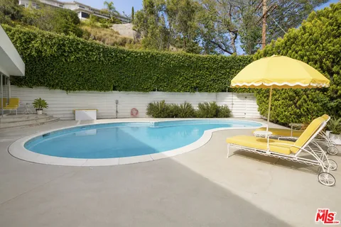 a view of a swimming pool with a yard and outdoor seating