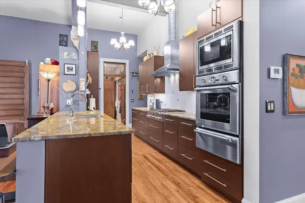 a bedroom with a bed a flat screen tv and chandelier