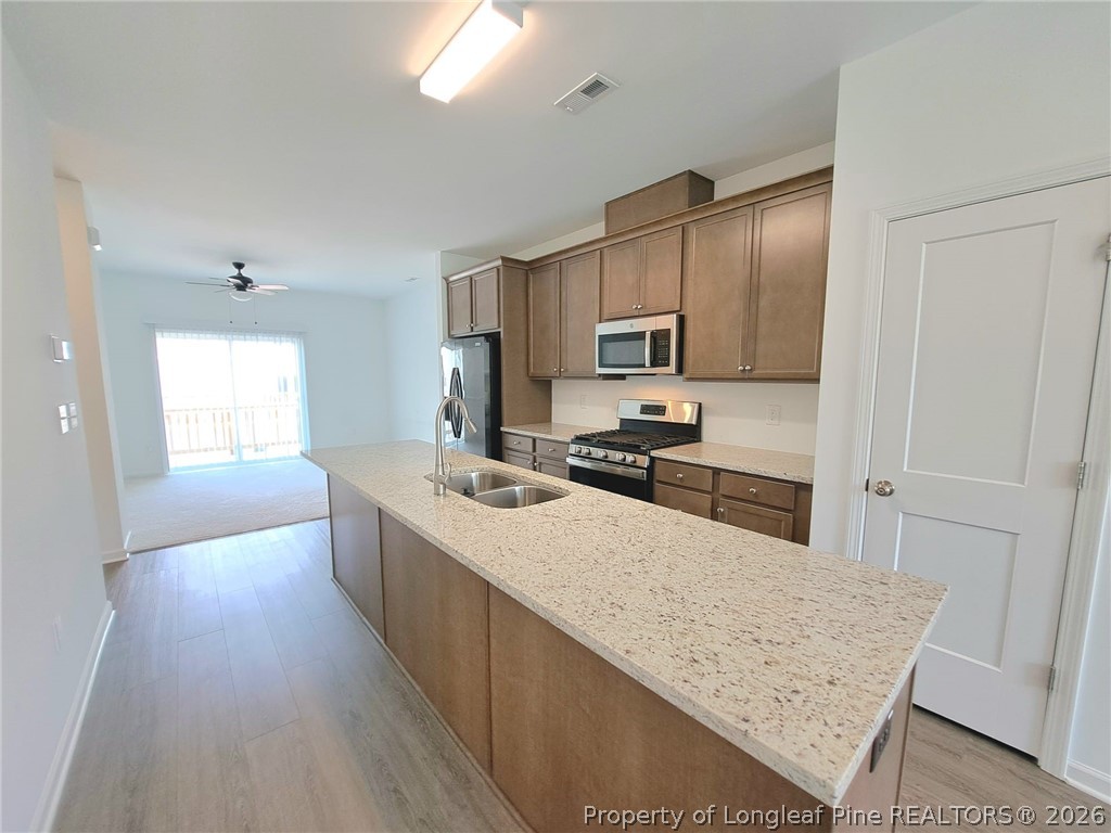 1939 Robin Hill Lane Raleigh, NC 27610 - Photo 10 of 25 a large kitchen with kitchen island a large counter top space a sink stainless steel appliances and cabinets
