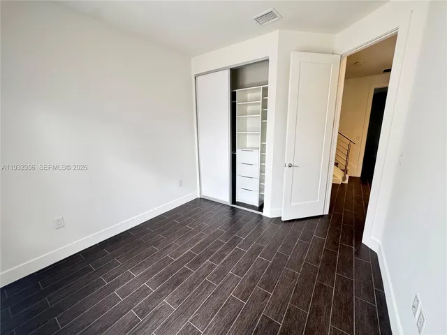 an empty room with wooden floor and entrance