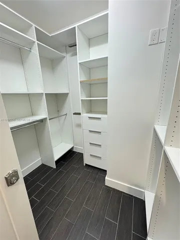 a view of walk in closet with empty racks