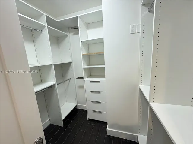 a large white kitchen with kitchen island granite countertop a large counter top stainless steel appliances and cabinets