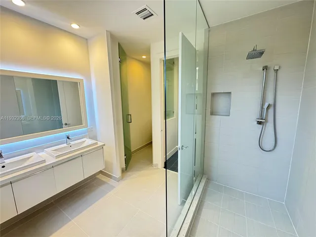 a bathroom with a tub shower and sink
