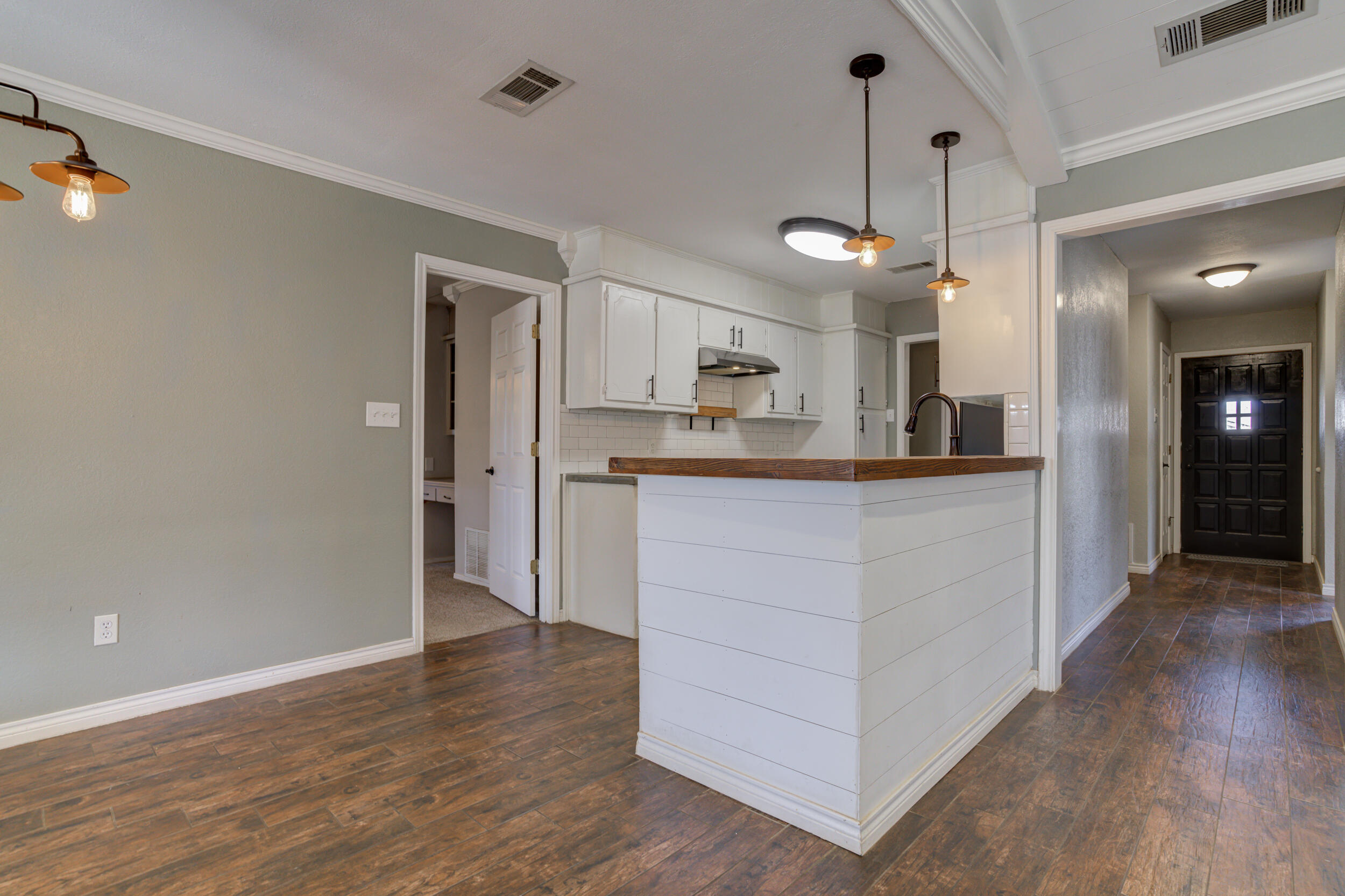 7106 Zoar Avenue Lubbock, TX 79424 - Photo 11 of 33 a kitchen with stainless steel appliances kitchen island a hardwood floor and a sink