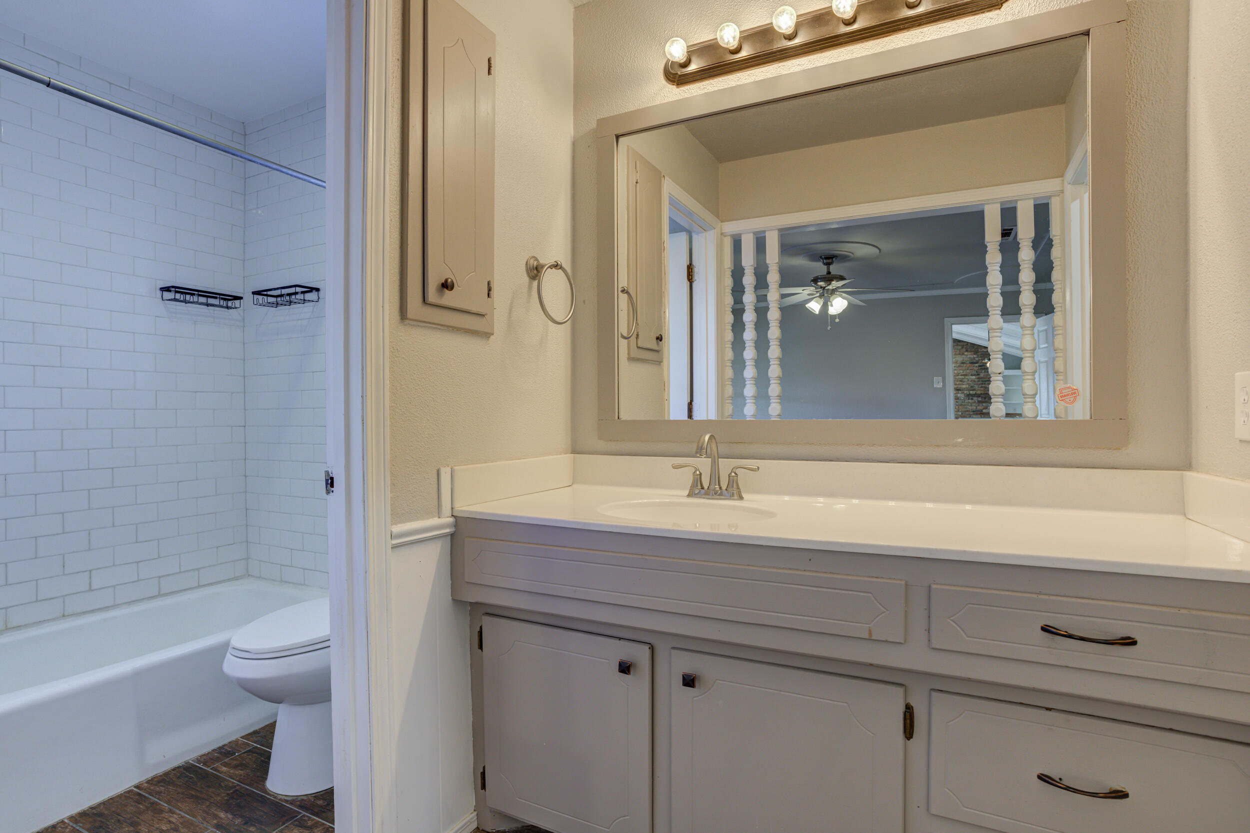 7106 Zoar Avenue Lubbock, TX 79424 - Photo 21 of 33 a bathroom with a granite countertop sink a toilet and shower