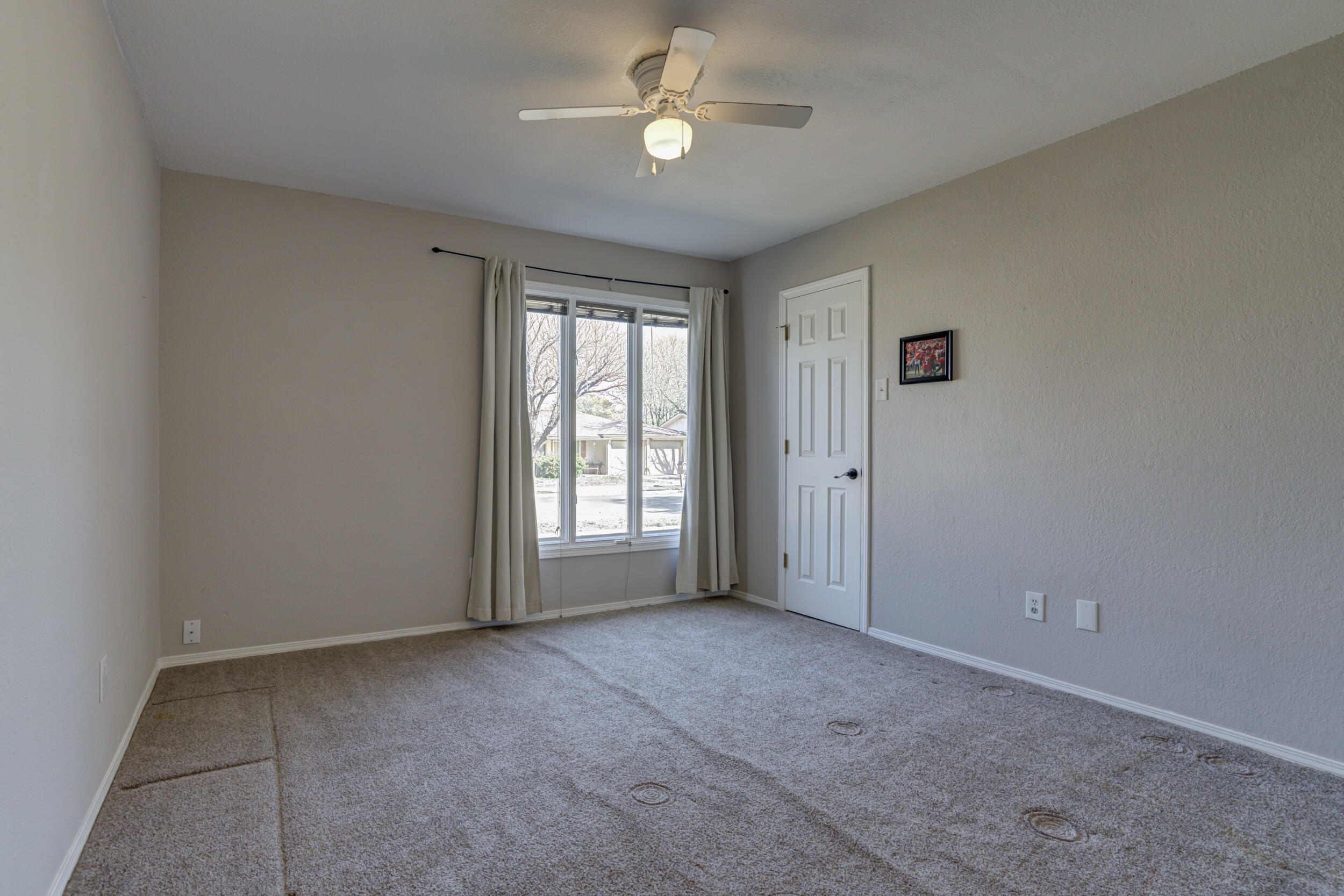 7106 Zoar Avenue Lubbock, TX 79424 - Photo 24 of 33 an empty room with windows and fan