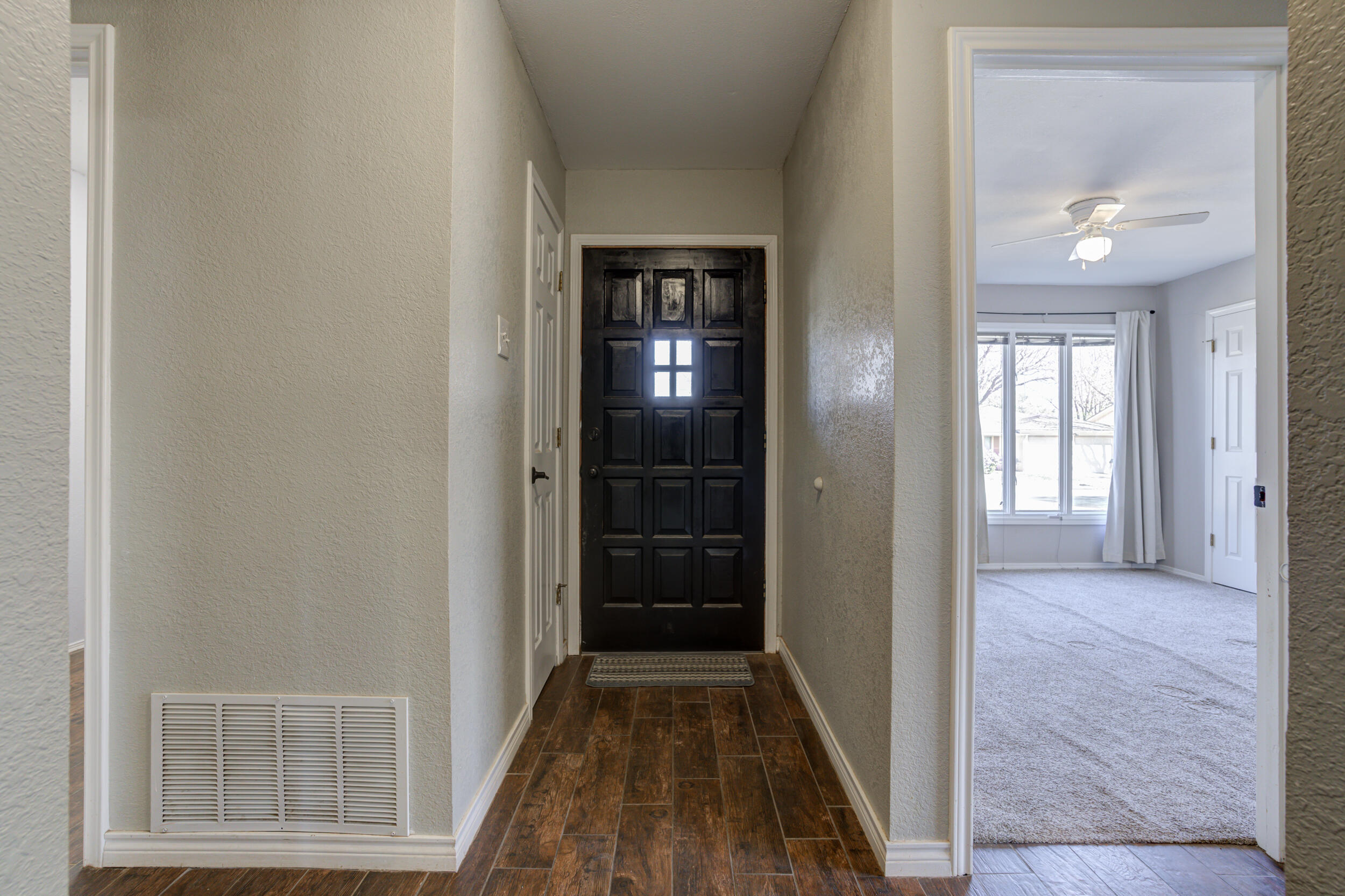 7106 Zoar Avenue Lubbock, TX 79424 - Photo 3 of 33 a view of hallway with an empty room and wooden floor