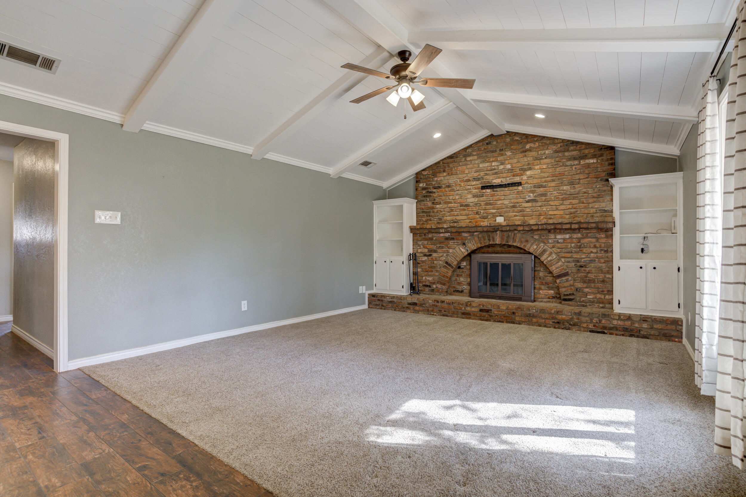 7106 Zoar Avenue Lubbock, TX 79424 - Photo 4 of 33 an empty room with fireplace fan and windows