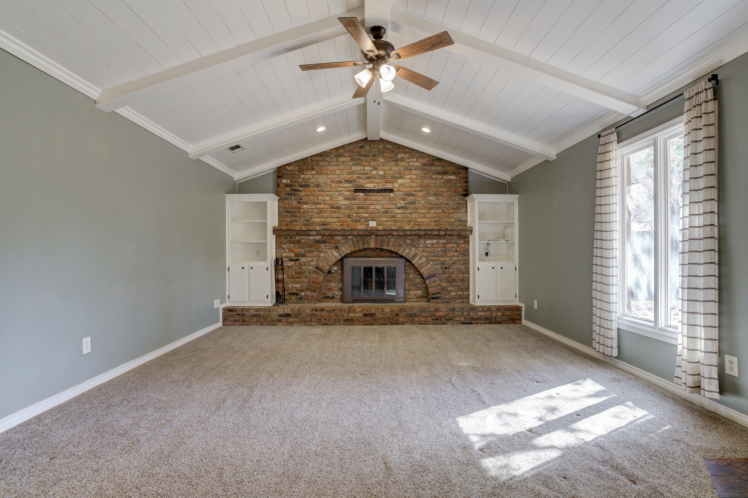 7106 Zoar Avenue Lubbock, TX 79424 - Photo 5 of 33 an empty room with windows and fireplace