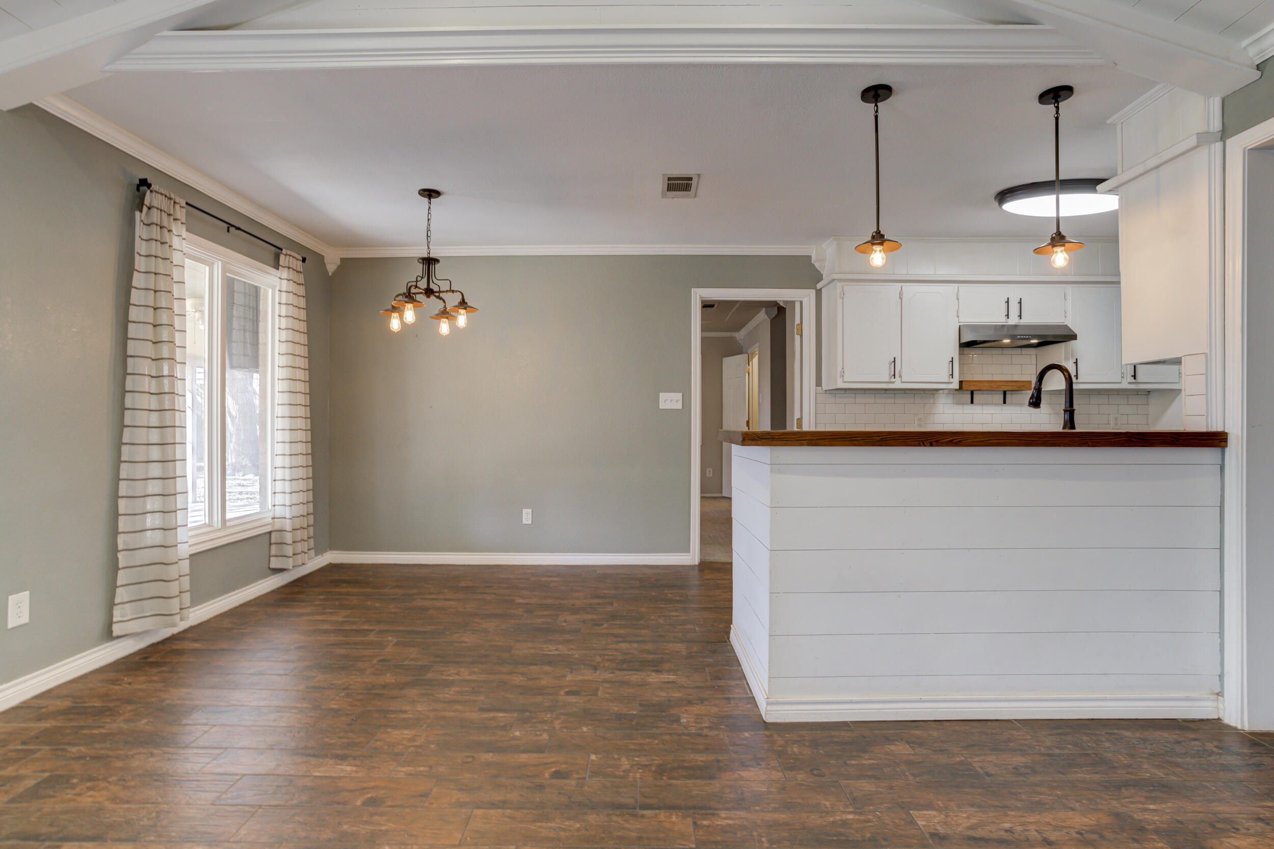 7106 Zoar Avenue Lubbock, TX 79424 - Photo 10 of 33 a view of a kitchen with a sink and dishwasher with wooden floor