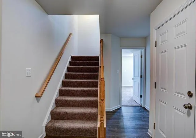 a view of a hallway with wooden floor and entryway