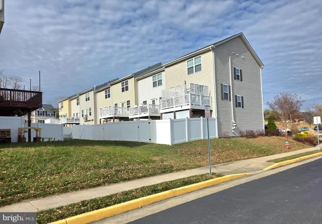 a view of a house with a yard and fence