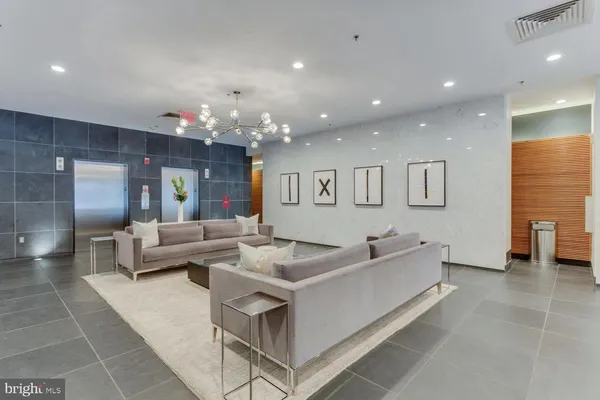 a living room with furniture and a chandelier