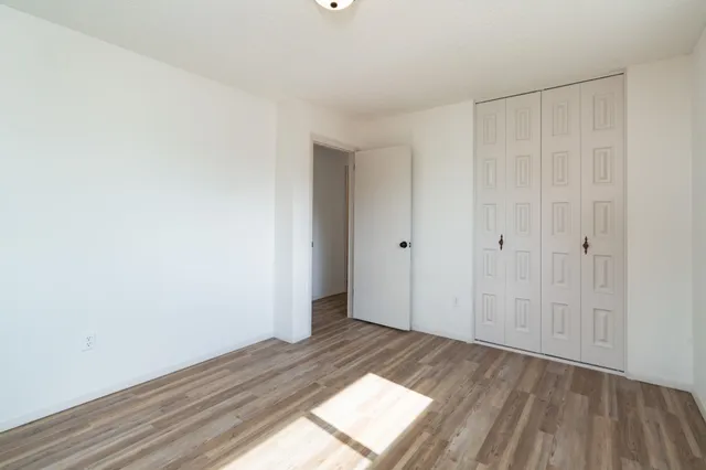 a view of a room with wooden floor and white walls