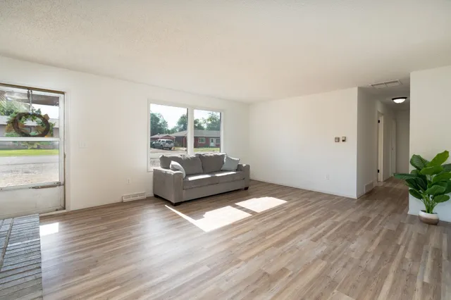 a view of a livingroom with wooden floor and furniture