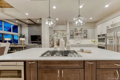 a view of a dining room with furniture a kitchen and chandelier