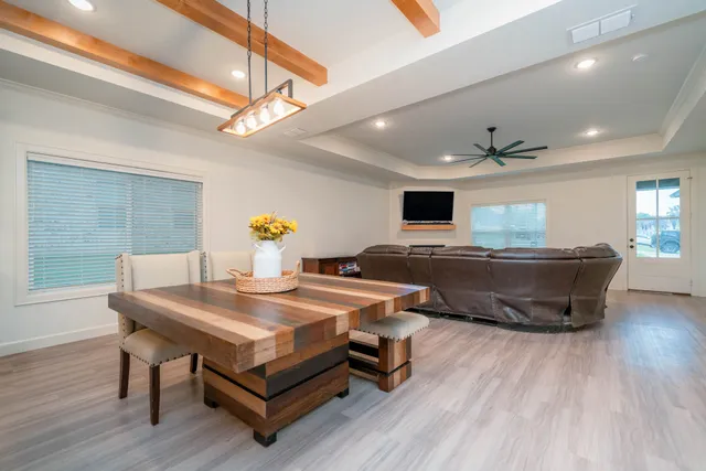 a living room with a table chairs and wooden floor