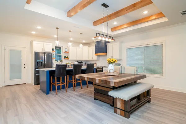a living room with stainless steel appliances kitchen island a table and chairs