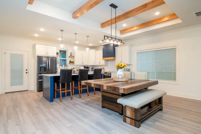 a living room with stainless steel appliances kitchen island a table and chairs