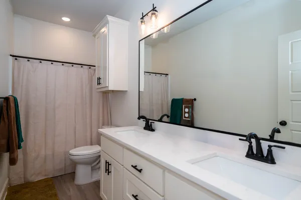 a bathroom with a sink a toilet and a mirror