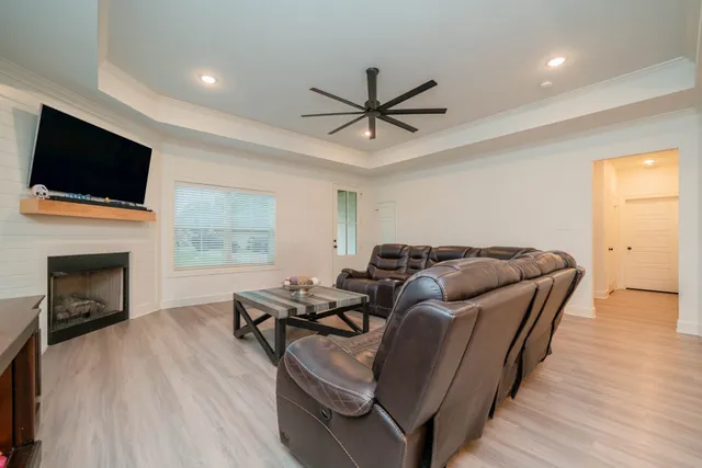 a living room with furniture a fireplace and a flat screen tv