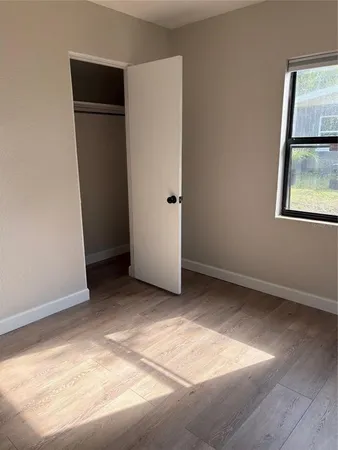 an empty room with closet and windows
