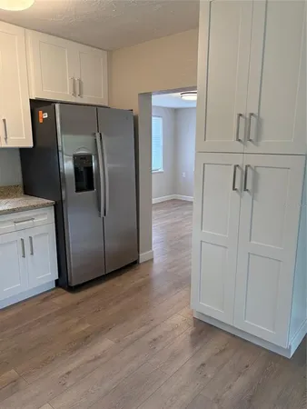 a kitchen with granite countertop white cabinets and stainless steel appliances