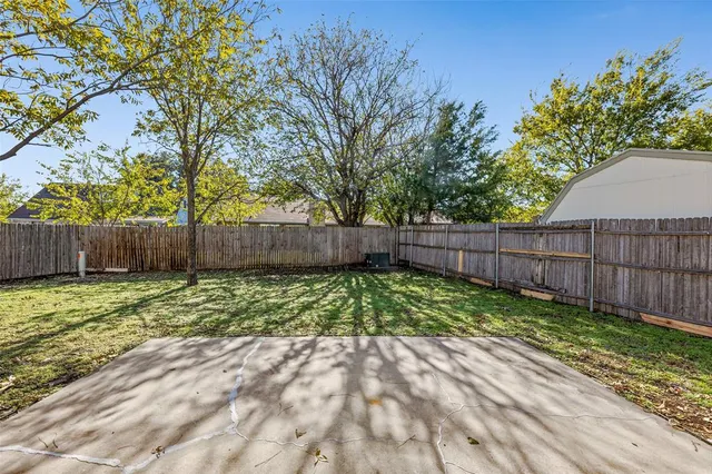 a view of backyard with wooden fence