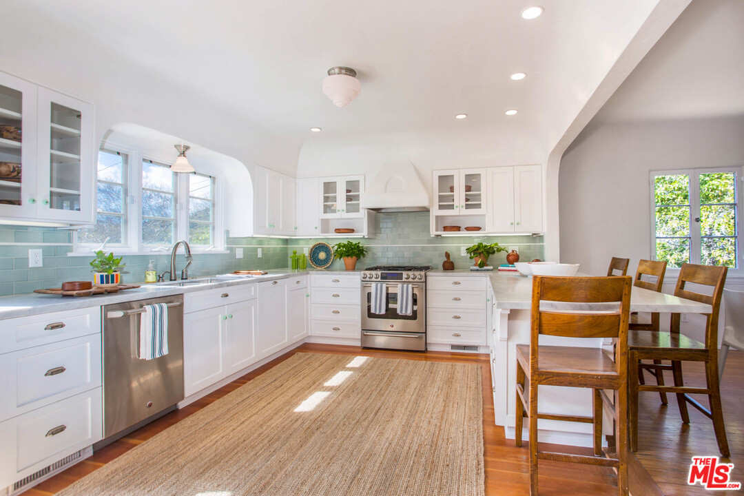 4541 Round Top Drive Los Angeles, CA 90065 - Photo 12 of 40 a kitchen with stainless steel appliances kitchen island wooden floors and white cabinets
